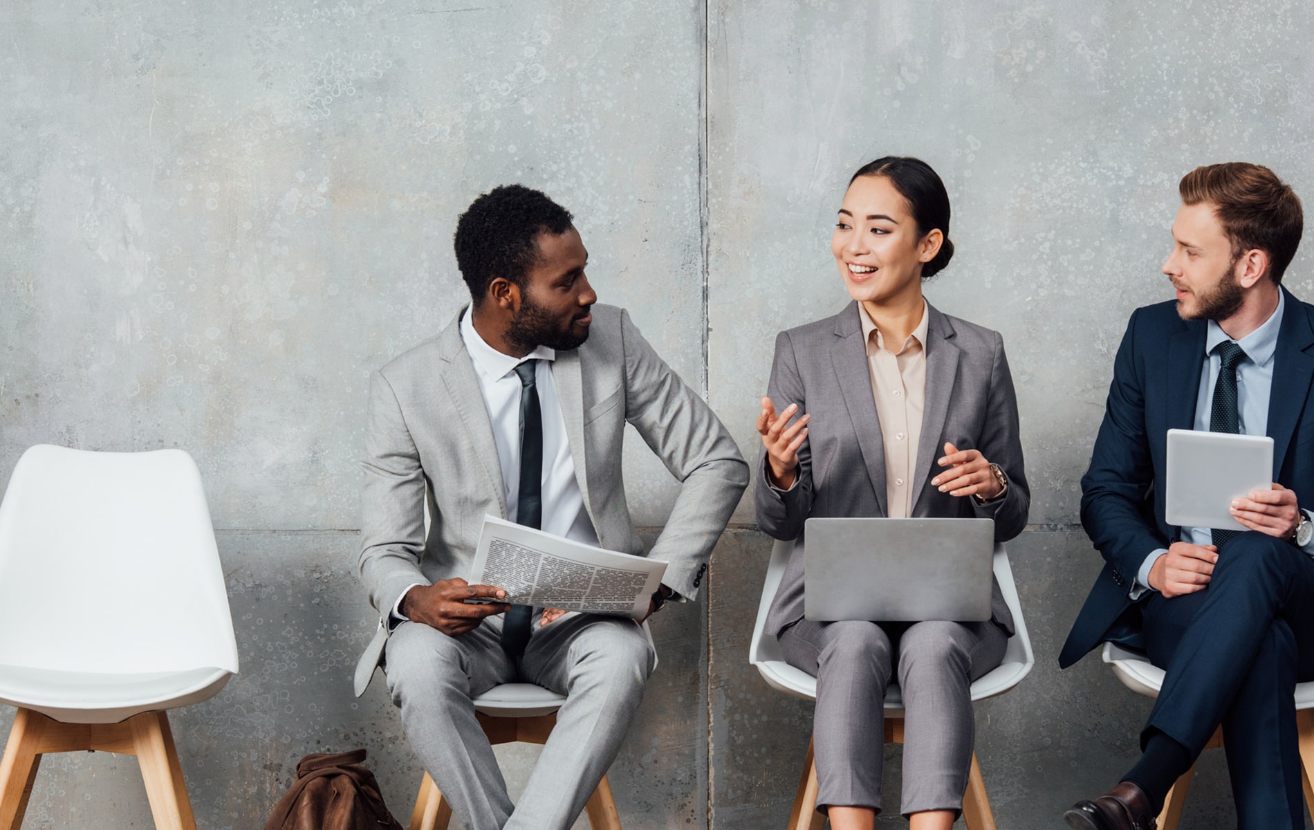 Two business men and one business woman in a discussion.