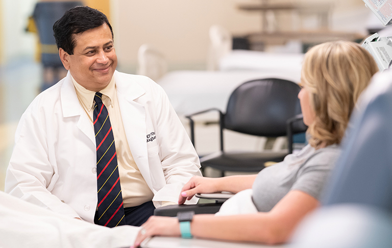 Dr. Raghavan smiling at patient receiving care.