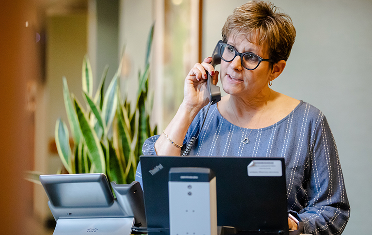 Office worker, Nancy, on an office phone.