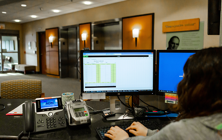 Front desk staff member on a computer.